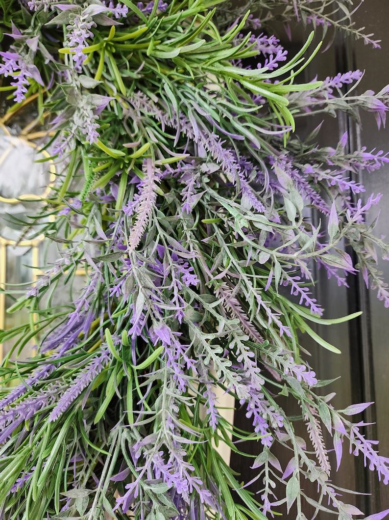 May include: A close-up of a lavender wreath with purple flowers and green leaves.