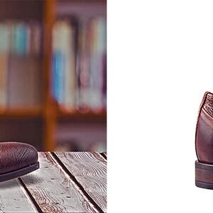 Pu&ograve; includere: Una scarpa oxford in pelle marrone con chiusura a lacci. La scarpa presenta un motivo testurizzato sul lato e una punta leggermente a punta.