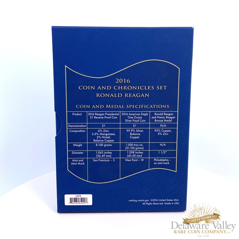 May include: A blue rectangular box for the 2016 Ronald Reagan Coin and Chronicles Set. The front features gold text detailing specifications for a $1 Reverse Proof Coin, a 1-ounce Silver Proof Coin, and a bronze medal, including weights and dimensions.