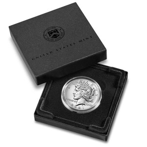 May include: A silver Peace dollar coin in a black velvet box with the inscription "UNITED STATES MINT".