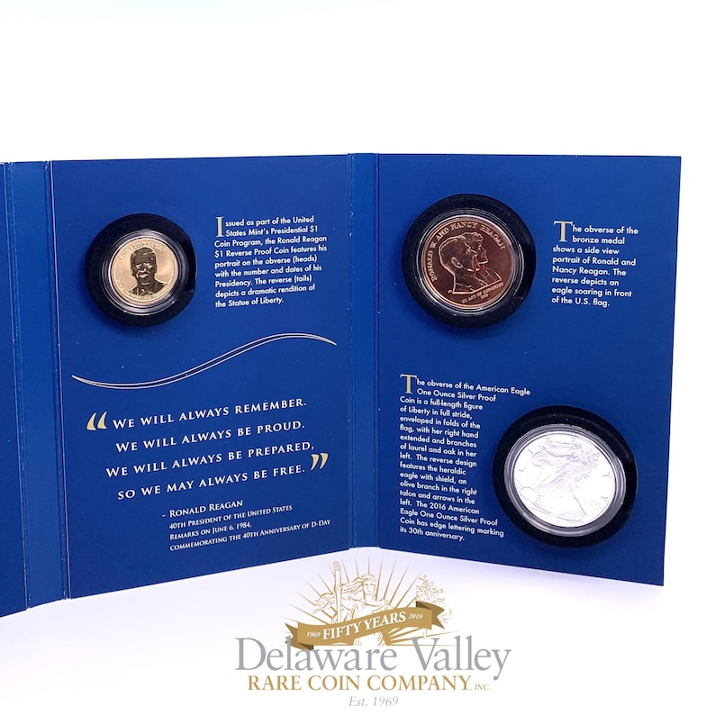 May include: A blue presentation folder containing three coins: a gold-colored Ronald Reagan dollar, a bronze medal featuring Ronald and Nancy Reagan, and a silver American Eagle coin. The folder includes printed text detailing the coin specifications.