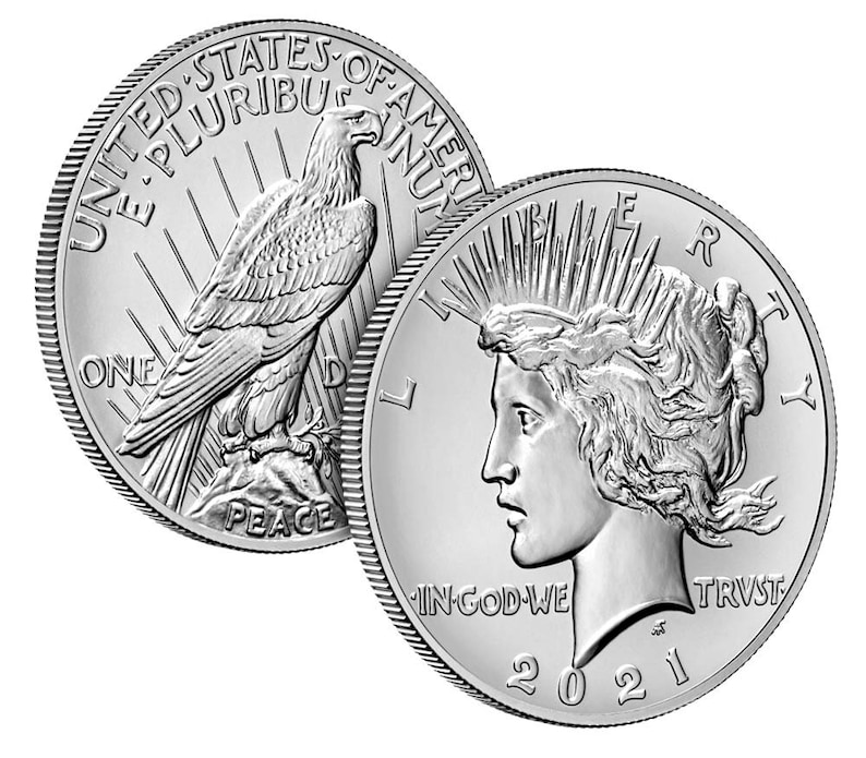 May include: Two silver American Peace dollar coins, one with an eagle on a branch and the inscription "E PLURIBUS UNUM", "UNITED STATES OF AMERICA", "ONE", and "PEACE", and the other with a profile of a woman with a crown of rays and the inscription "LIBERTY", "IN GOD WE TRUST", and "2021".