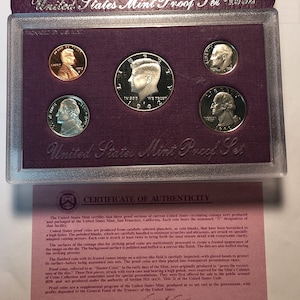 May include: A purple velvet presentation case with a certificate of authenticity for a 1992 United States Mint Proof Set. The set includes six coins: a 1992-S Lincoln penny, a 1992-S Jefferson nickel, a 1992-S Roosevelt dime, a 1992-S Kennedy half-dollar, a 1992-S Washington quarter, and a 1992-S Sacagawea dollar.