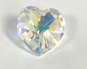 May include: A clear iridescent heart-shaped crystal with a faceted design. The crystal has a hole at the top for hanging.