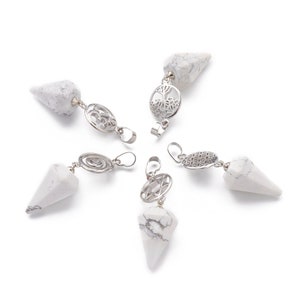 May include: Five white howlite crystal pendants with silver metal charms. The charms include a tree of life, a spiral, a star of David, a flower of life, and an om symbol.