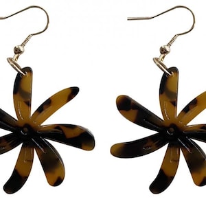 Pode incluir: Um par de brincos em forma de flor com padrão tartaruga. Os brincos têm um gancho dourado e um design de seis pétalas. As pétalas são uma mistura de castanho e preto, criando um acessório único e elegante.
