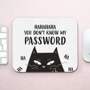 Puede incluir: Una alfombrilla de ratón rectangular blanca con una ilustración de un gato negro con nariz rosa y ojos entrecerrados. El texto dice: HAHAHAHA YOU DON'T KNOW MY PASSWORD, rodeado por la palabra HA repetida cuatro veces en letras negras.