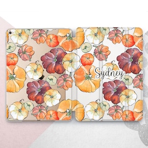 May include: A white iPad case with a watercolor pattern of orange, brown, and white pumpkins. The name "Sydney" is written in white on the case.