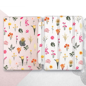 Puede incluir: Una funda para iPad con la parte posterior transparente y un diseño floral. La funda tiene una función de soporte y una solapa que cubre la pantalla. El diseño es rosa, blanco y amarillo.