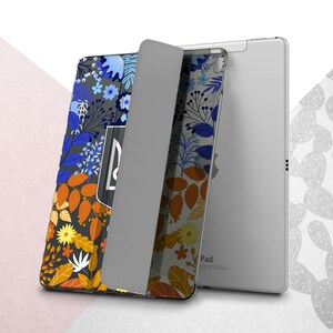 Peut inclure: Une coque pour iPad avec un motif floral dans les tons de bleu, orange, jaune et blanc sur un fond gris fonc&eacute;. L'&eacute;tui est ouvert, r&eacute;v&eacute;lant l'&eacute;cran et le logo Apple. Le motif comprend des feuilles et des fleurs.