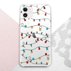 May include: Clear phone case with a festive design of colorful Christmas lights. The lights are red, yellow, blue, and green, strung across the case. The phone case is designed for an iPhone.