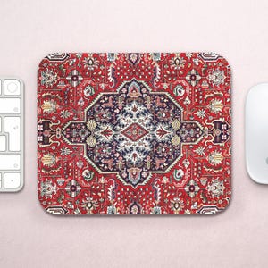 May include: Rectangular mousepad with a Persian rug design. The pad features a red background with a detailed pattern in navy, white, and gold. The design includes floral and geometric elements.