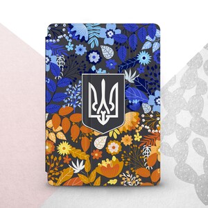 Peut inclure: &Eacute;tui pour tablette avec un motif floral bleu, orange et jaune sur fond gris fonc&eacute;. Il pr&eacute;sente un embl&egrave;me argent&eacute; et noir. Le design comprend diverses fleurs et feuilles.