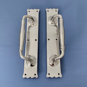 Peut inclure: Deux poignées de porte en nickel poli avec une plaque arrière décorative et une poignée à levier. Les poignées ont un design traditionnel.