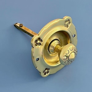May include: A brass door knob with a floral design. The knob is round with a decorative pattern, and the backplate features embossed flowers. The hardware is a bright gold color.