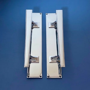 May include: Two silver door handles with a rectangular backplate and a long, narrow lever.