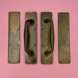 Puede incluir: Cuatro tiradores de puerta de latón antiguo con un diseño simple y elegante. Cada tirador tiene una placa rectangular y una manija curva en forma de D.