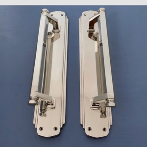 Peut inclure: Une paire de poignées de porte en nickel poli avec une plaque arrière rectangulaire et un levier long et droit. Les poignées ont un design géométrique et sont de style moderne.