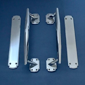 Pode incluir: Conjunto de ferragens para portas em cromo polido. O conjunto inclui duas placas retangulares longas, duas maçanetas e duas placas de trinco. A ferragem tem um design elegante e moderno com uma superfície reflexiva.