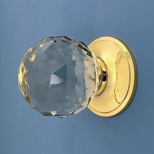 Manilla de puerta principal decorativa de latón recuperado con pomo central de cristal tallado grande, estilo vintage.