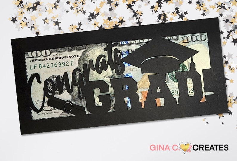 May include: Black cardstock money holder with a cut-out design that says "Congrats Grad!" with a graduation cap and a diploma. A $100 bill is visible through the cut-out.