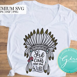 May include: White t-shirt with a black and gold graphic of a Native American headdress with the text "She Can and She Will!" printed on it. The graphic is surrounded by a turquoise circle with the text "SVG'S & CRAFTS Gina C.CREATES GRAPHIC DESIGNER".