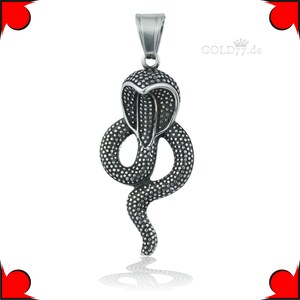 Op de afbeelding: Een zilverkleurige hanger in de vorm van een cobra met een getextureerd oppervlak. De hanger heeft een lus aan de bovenkant om aan een ketting te bevestigen.