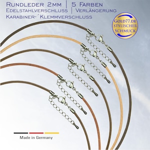 Könnte beinhalten: Fünf Lederbänder mit einem silbernen Verschluss und einer Verlängerungskette. Die Bänder sind in den Farben Beige, Braun, Dunkelbraun, Hellbraun und Rot. Der Text "RUNDLEDER 2MM 5 FARBEN EDELSTAHLVERSCHLUSS VERLÄNGERUNG KARABINER- KLEMMVERSCHLUSS Made in Germany GOLD77.DE STYLISCHER SCHMUCK" ist im Bild sichtbar.