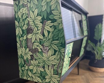 1950s Vintage drinks cabinet professionally refinished in Cole & Son's Fornasetti 'Folie e Scimmie' in Forest Green and gloss black frame