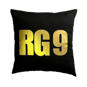 Può includere: Cuscino nero con scritta dorata "RG9".