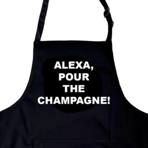 Op de afbeelding: Zwarte schort met witte tekst die "Alexa, schenk de champagne in!" zegt.