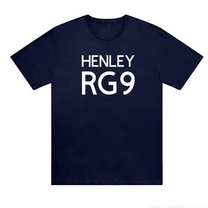 May include: A navy blue t-shirt featuring the white text "HENLEY RG9". The shirt has a crew neck and short sleeves. The material looks like a soft cotton blend. A casual, everyday garment.