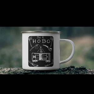 May include: White enamel camping mug with a black and white illustration of a train car and the text "Be a Hobo".