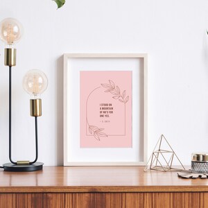 May include: A framed print with a pink background and a quote in brown text that reads "I stood on a mountain of no's for one yes." The quote is surrounded by a line drawing of leaves and a half circle.