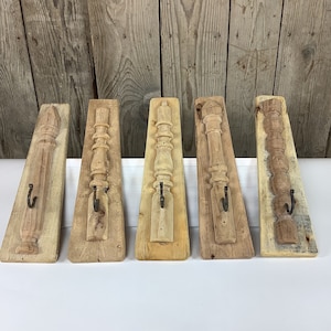 May include: Five rustic wooden wall hooks with metal hooks. Each hook is made from reclaimed wood and features a unique design. The hooks are perfect for hanging coats, hats, or other items.
