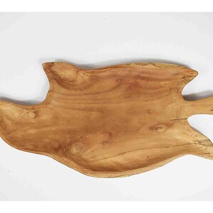 May include: A natural wood serving tray shaped like a fish. The tray is made of light brown wood and has a smooth, polished finish.