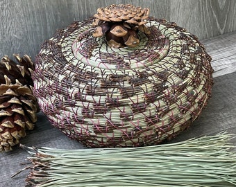 Pine-needle basket, green Ponderosa pine needles, peach wood center,  fuchsia waxed Irish linen thread, pine-cone lid, subtle shades of pink