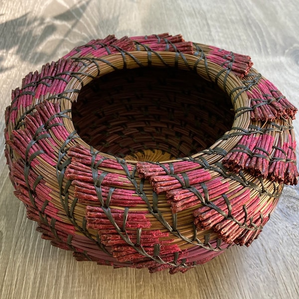 Pine-needle basket, green Ponderosa dyed fuchsia, macadamia wood center, black stitching, pink basket, glycerin treated needles.