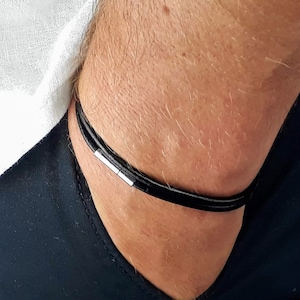 May include: A black leather choker necklace with a silver magnetic clasp.
