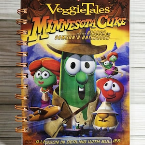May include: A DVD of the animated children's movie "VeggieTales: Minnesota Cuke and the Search for Samson's Hairbrush." The cover features cartoon vegetables and the text "A Lesson in Dealing with Bullies."