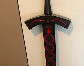 May include: A black and red sword with a decorative handle and a book titled "Operating System Design" by Douglas Comer.