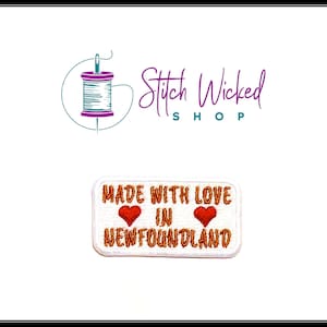 May include: White rectangular embroidered patch with the text "Made with love in Newfoundland" and two red hearts.