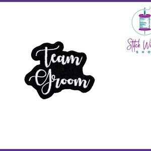 Op de afbeelding: Zwarte strijkpatch met witte geborduurde tekst "Team Groom".