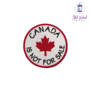 Peut inclure: Un écusson brodé circulaire blanc avec une feuille d'érable rouge et le texte "CANADA IS NOT FOR SALE".