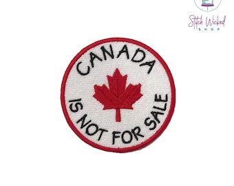 May include: A white circular embroidered patch with a red maple leaf and the text "CANADA IS NOT FOR SALE".
