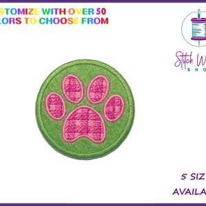 May include: Green paw print embroidered patch with a pink paw print in the centre. The patch is round and has a white background. "Stitch Wicked Shop" is written in the top right corner of the image. "5 Sizes Available" is written in the bottom right corner of the image.