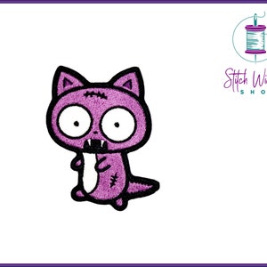 May include: Purple embroidered iron-on patch of a cartoon zombie cat with big eyes and fangs.