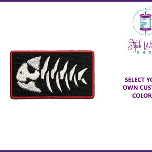 May include: White embroidered fish skeleton on a black background with a red border. The text "Select your own custom colors" is visible below the image.
