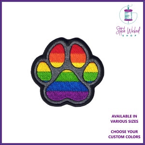 May include: Rainbow paw print embroidered patch with a grey outline. Stitch Wicked Shop is printed in the top right corner.