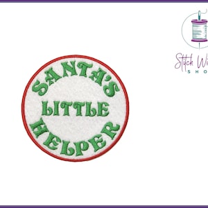 May include: A round, white, embroidered patch with a red border. The text "SANTA'S LITTLE HELPER" is written in green cursive.